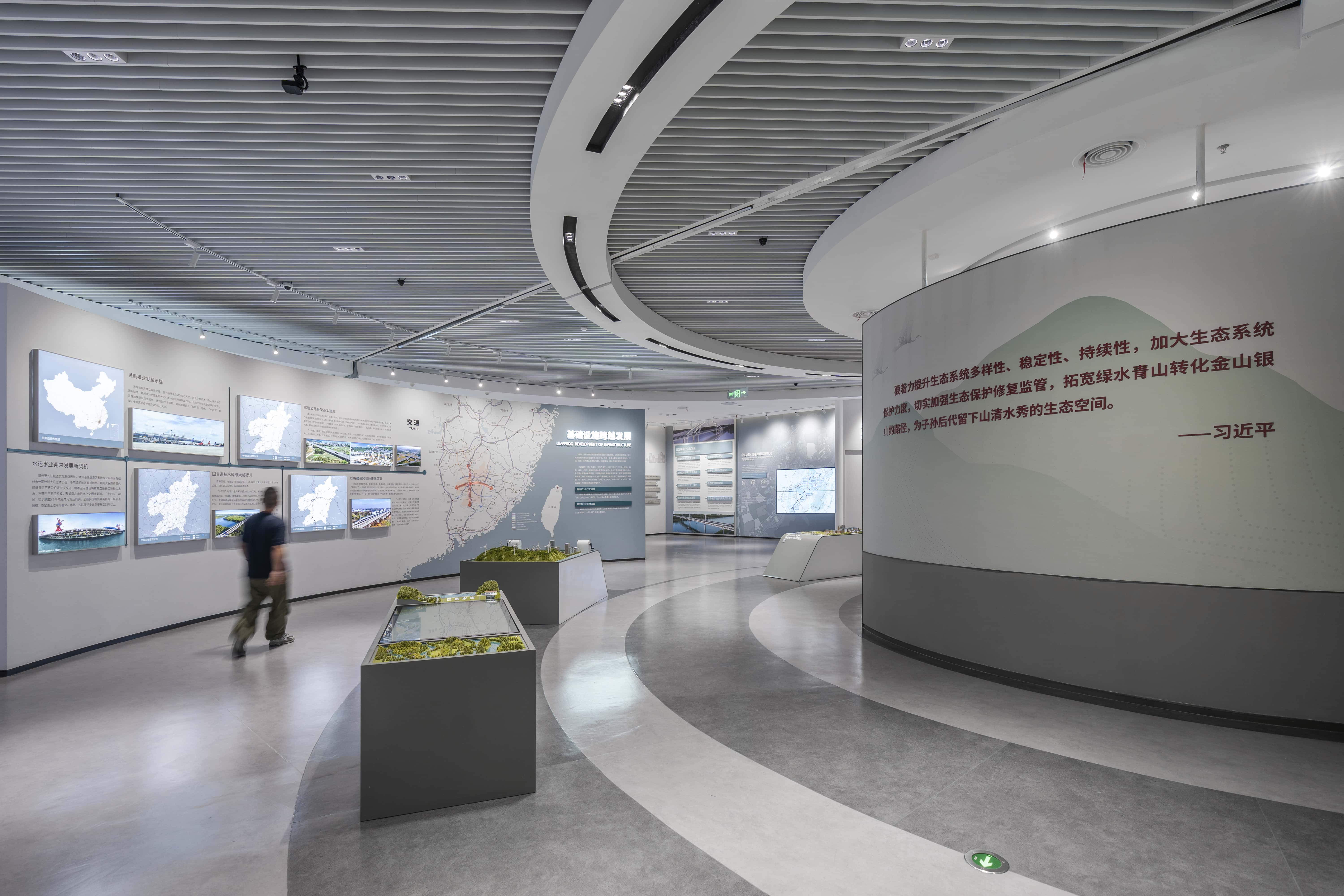 According to the overall layout of the Five in One construction，depict the future development vision of Ganzhou through graphic and textual exhibition walls and model island platforms.